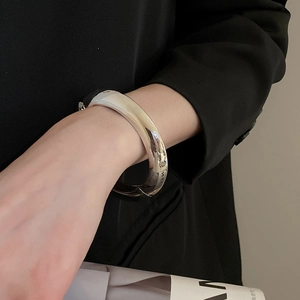 Polished silver wide cuff bracelet styled with a black professional blazer for a modern look