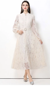 Détail de la dentelle florale élégante et des boutons frontaux sur robe blanche longue