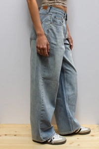 Side view of light blue wide-leg denim jeans showing relaxed fit and high waist style