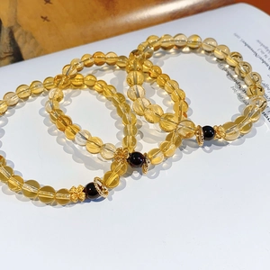 Detailed macro view of citrine beaded bracelets with garnet accents and golden flower spacers