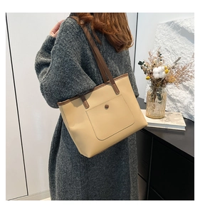 Détail du sac cabas minimaliste avec bandoulière marron contrastée et poche boutonnée