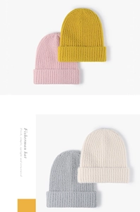 Detailed knit texture of four colored beanies showing ribbing and thick yarn quality