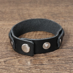 Detail of vintage black multi-layer leather bracelet with silver metal snap buttons