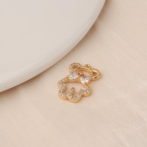 Close-up of gold-plated bear pendant with zircon inlay on minimalist ceramic plate