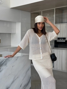 Detail view of a beige crochet knit cardigan set with hollow-out patterns and buttons