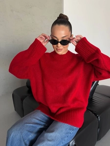 Detail of loose oversized red knit sweater featuring a fuzzy texture and ribbed crewneck