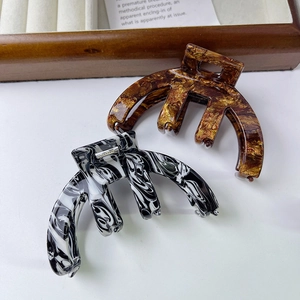 Arched acetate hair claws set in marble and tortoiseshell patterns for women