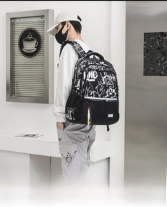 Close-up of black graffiti backpack featuring side mesh pocket and yellow strap detail