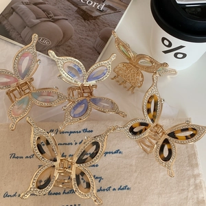 Detailed close-up of 5-piece set elegant rhinestone butterfly hair claws in gold finish