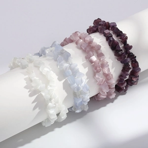 Detail showing four colorful cat eye stone bracelets in white, blue, and purple hues