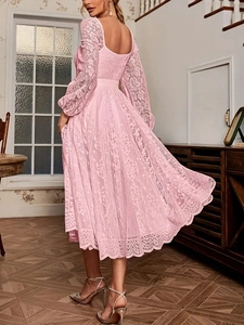 Gros plan d'une robe en dentelle rose élégante avec motifs floraux et taille ajustée