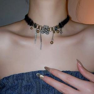 Detailed close-up of velvet choker with rhinestone bear, pearls and star fringe tassel