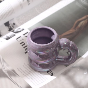 Chic bubble design purple ceramic mug with iridescent pearl finish on newspaper