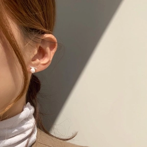 Minimalist 925 sterling silver pearl stud earrings shown on a model for elegant women's style
