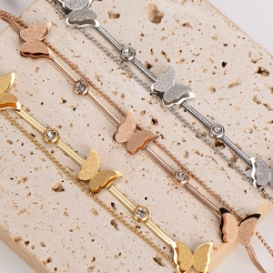 Detail of frosted butterfly bracelets in gold, rose gold and silver on stone