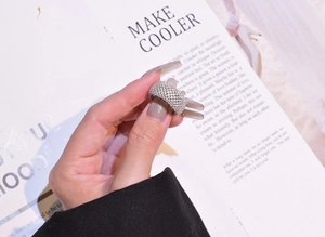 Macro detail of wide pavé band ring with micro-set zircons on silver plating
