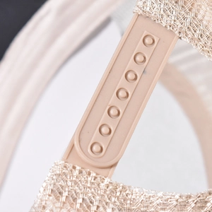 Detail of adjustable snapback closure and mesh fabric on a beige baseball cap