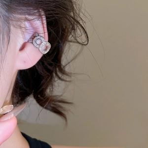 Silver hollow zircon ear cuff with triple-layered rings worn on a woman ear