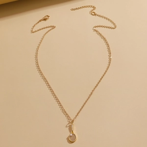 Detail of gold tennis racket necklace with sparkling crystals and a white pearl charm