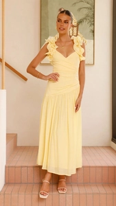 Détail des épaules à volants et du col en V croisé sur cette robe longue jaune élégante