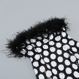 Close-up of black and white polka dot sequins with plush ostrich feather trim detailing