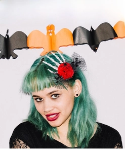 Detail of Halloween skeleton hand hair clip with red rose and mesh on green hair