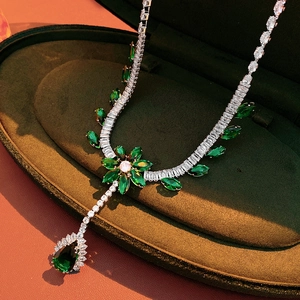 Detail showing an emerald zircon flower necklace with teardrop pendant in a velvet box