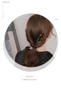 Detailed view of a tortoise shell resin U-shaped hairpin in a minimalist hair style
