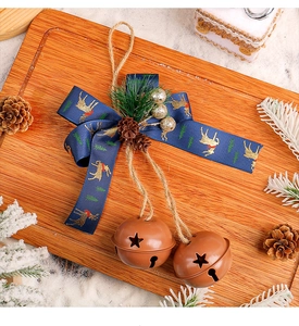 Detail of Christmas iron bells with blue deer ribbon, pine cones and pine needles decoration