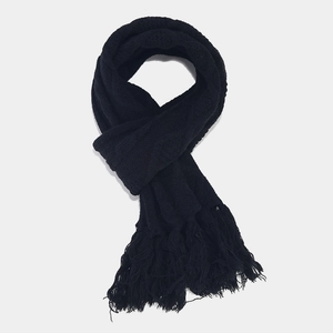 Detail view of the black knitted winter scarf with soft long fringe and thick texture