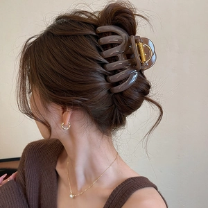 Amber acrylic hair claw clip for thick hair shown in a low ponytail on brunette hair