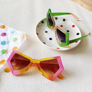 Fashionable oversized butterfly cat-eye sunglasses with gradient frames on a prop surface