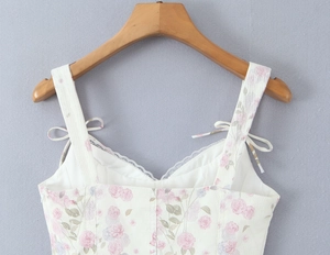 Detailed view of floral spaghetti strap top with lace trim and delicate bow accent