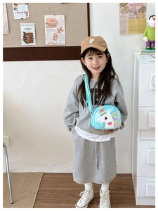 Detailed view of child wearing lake blue unicorn crossbody bag and khaki P baseball cap