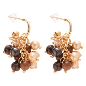 Golden geometric tassel earrings with tiger eye stones and zircon on white background
