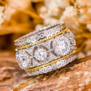 Macro detail of luxury two-tone ring with three circular stones and pave setting