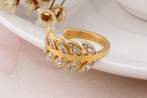Macro d'une bague feuille dorée avec zircons étincelants et anneau ajustable ouvert