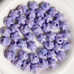 Macro shot of purple aurora star beads in a white bowl for DIY jewelry making accessories