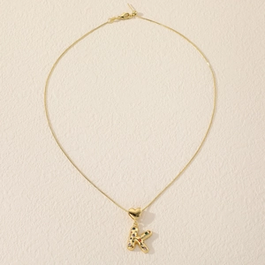 Detail view of golden initial K necklace pendant with colorful crystals and heart detail