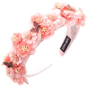 Detail of handmade pink mesh flower headband with sparkling purple butterfly and label