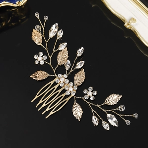Macro view of bridal hair comb with gold leaves, clear crystals, and small pearls