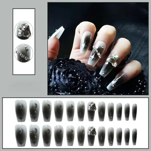 Detail of grey ombre coffin press-on nails with stars, moon patterns and luxury rhinestones