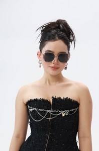 Detail shot of oversized square sunglasses with slim silver metal legs and dark lenses
