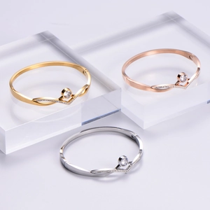 Three V-shaped stainless steel bracelets in gold, silver and rose gold with zircon