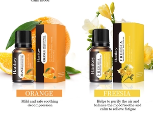 Vue détaillée des huiles essentielles 10ml Orange et Freesia avec emballage et fruits
