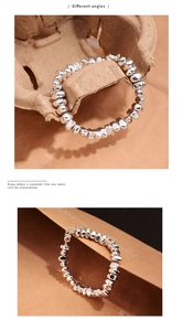 Close-up detail of silver geometric beaded bracelet with irregular polished finish
