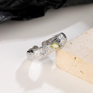 Macro detail of silver lava texture ring featuring an olive yellow stone on a stone base