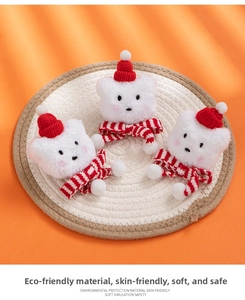 Detailed view of plush Christmas cat head ornaments with red scarves and festive hats