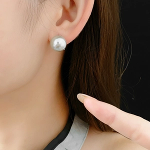 Close-up of 12mm silver-gray pearl ear clip worn on ear with metallic luster