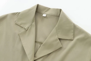 Detailed close-up of khaki poplin shirt collar with stitching and S size label